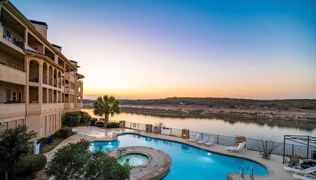 a large swimming pool next to a river at Color Pop by the Pool in Lago Vista