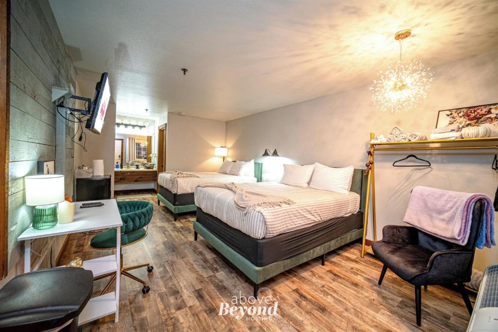 a hotel room with two beds and a chair at Glam Jam! - Newly Remodeled Stay in Style! Pets Stay Free in Branson