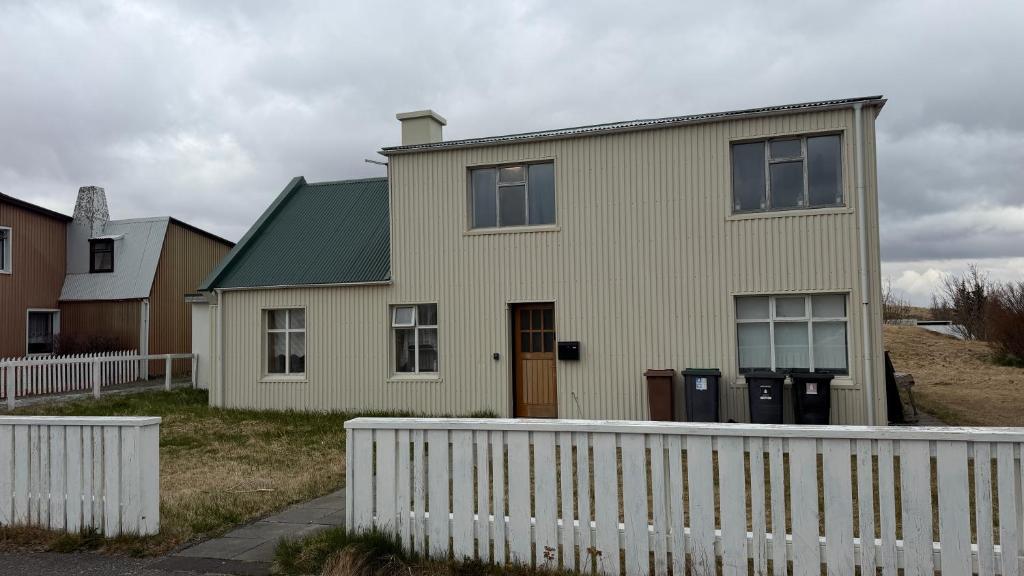 a house with a white fence in front of it at Ocean View Guesthouse in Borgarnes