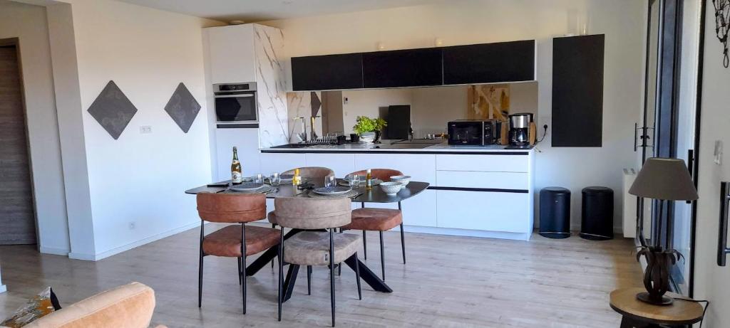a kitchen with a table and some chairs in a room at Le Vivastella in Cucq