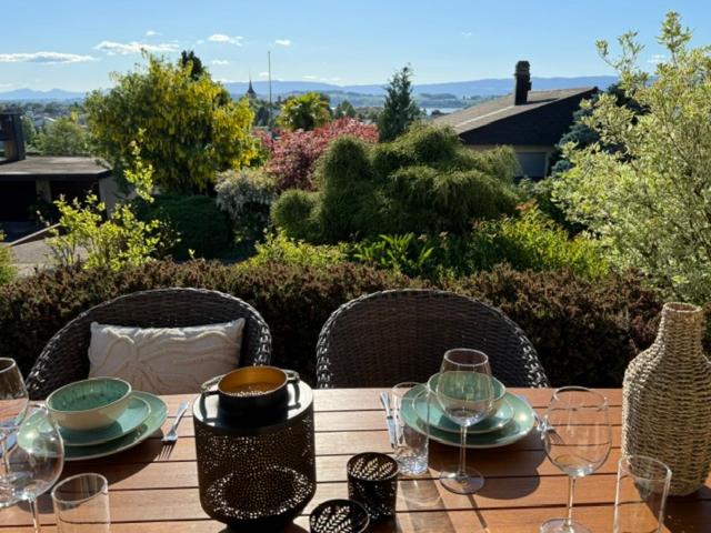 a wooden table with plates and wine glasses on it at inHome Vista Murten in Murten