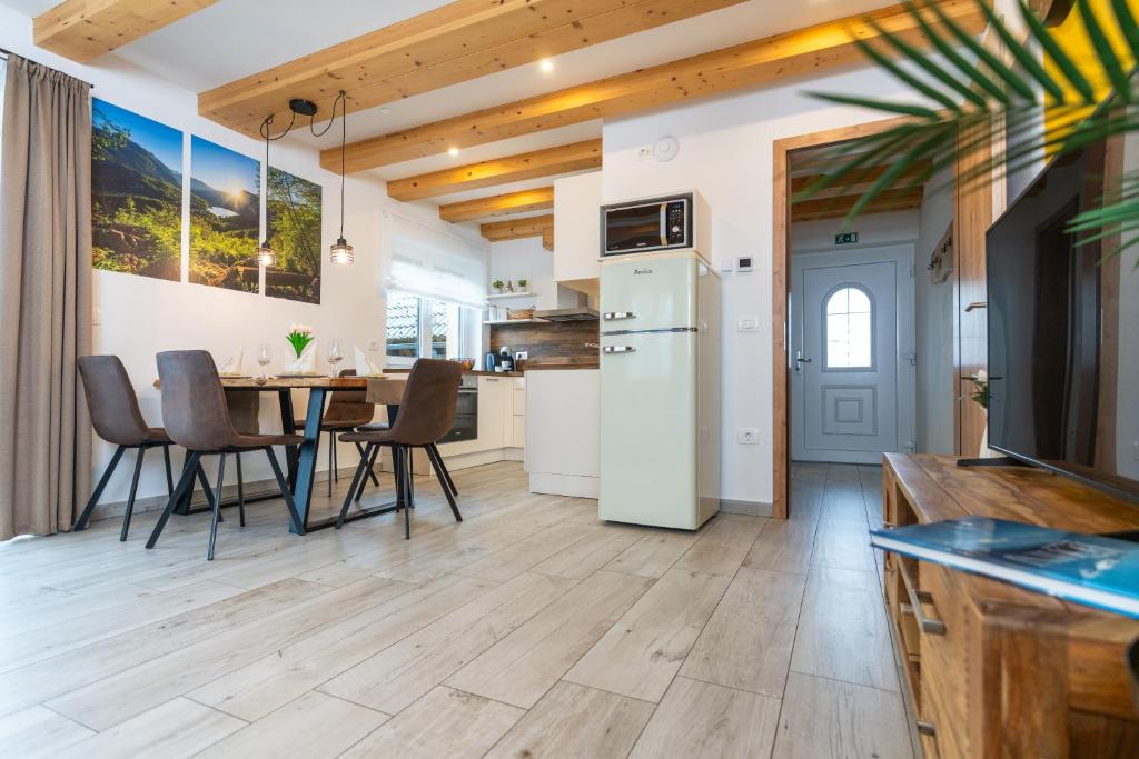 a kitchen and dining room with a table and chairs at Apartmaji MM in Bohinj