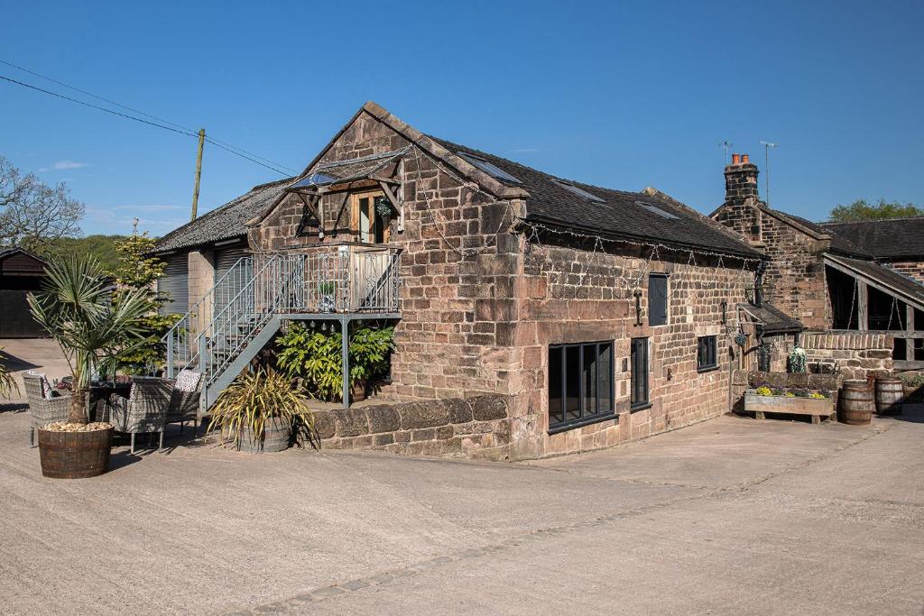 an old brick building with a balcony on it at The Damson Barn in Biddulph