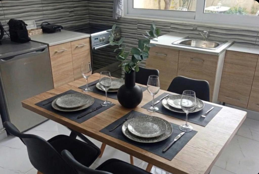 ein Holztisch mit Tellern und Weingläsern darauf in der Unterkunft Lemon Suites in Mytilini