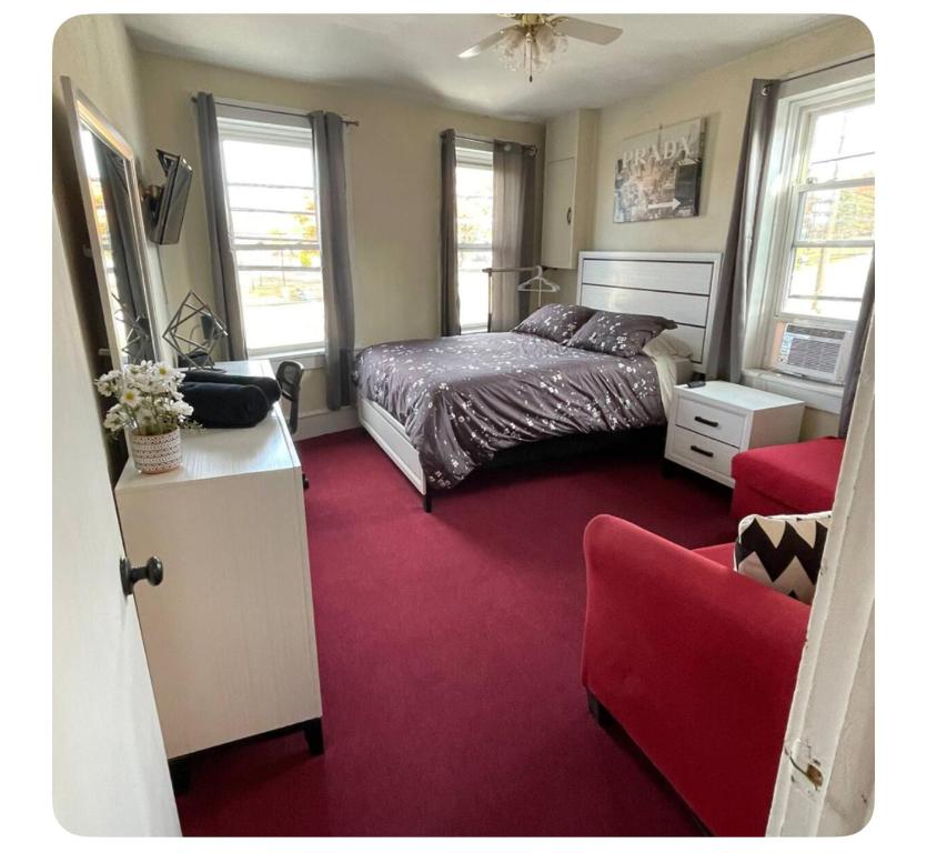 a bedroom with a bed and a red carpet at Serendipity Corner Guesthouse in Wilkes-Barre