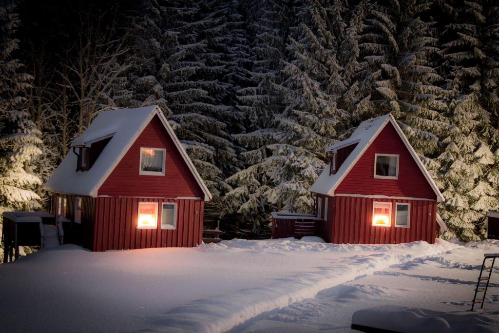 two red cabins in the snow at night at Erzgebirgsidyll in Breitenbrunn