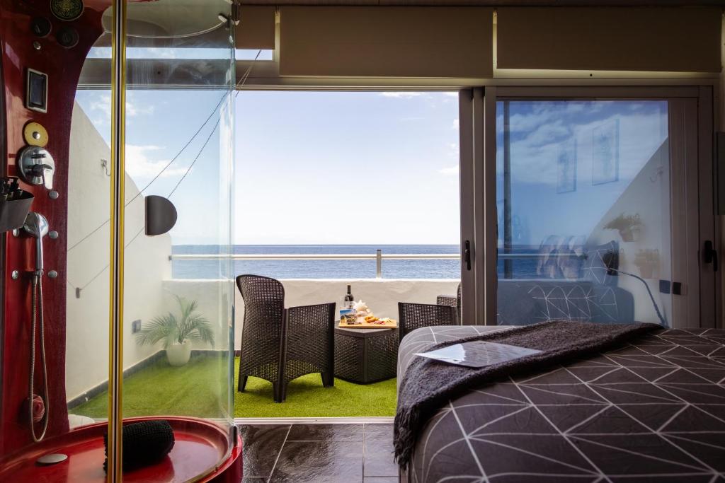 a room with a bed and a view of the ocean at Live Puertito Neptune Beach in Puertito de Güímar