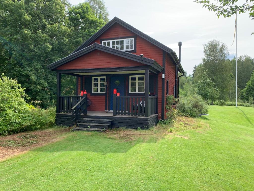 a small red house with a green yard at Mosters hus in Gansbyn