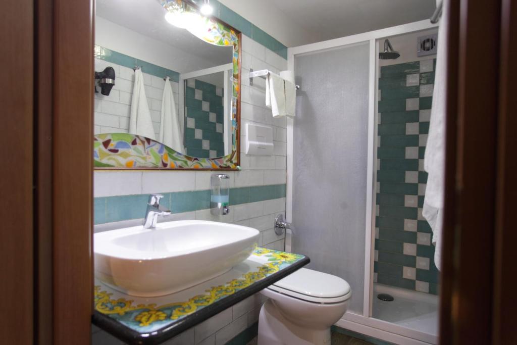 łazienka z umywalką, toaletą i lustrem w obiekcie Aurora Bed and Breakfast w mieście Santo Stefano di Camastra