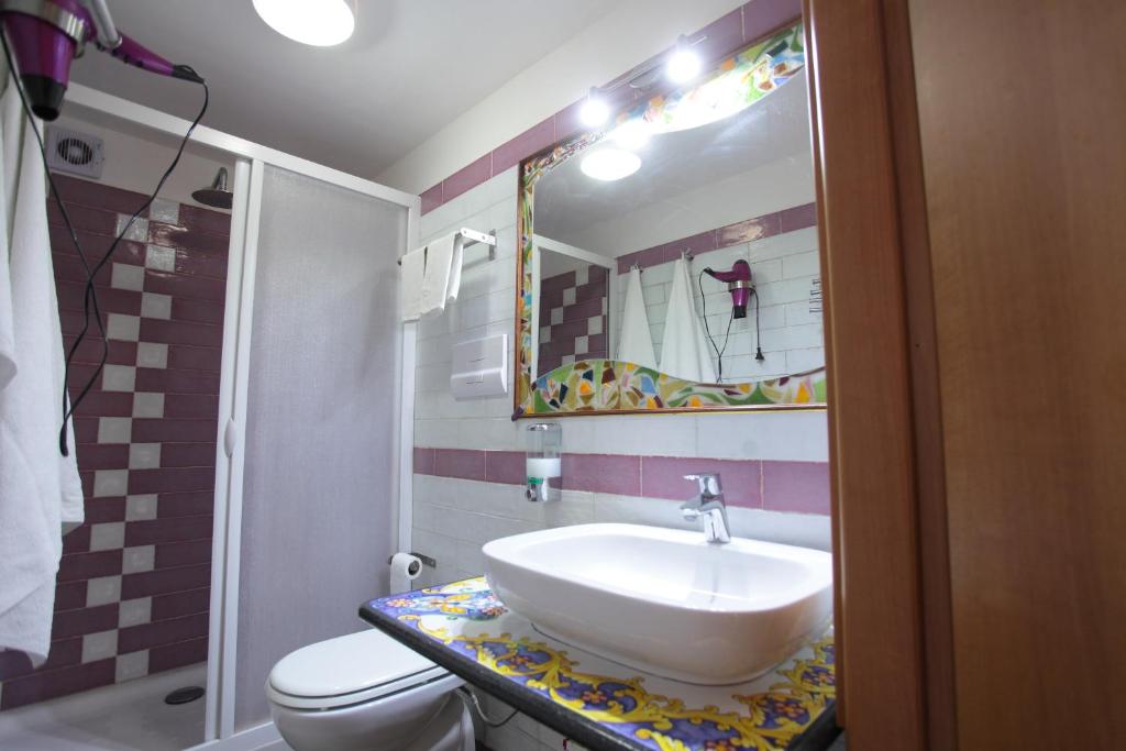 łazienka z umywalką, toaletą i lustrem w obiekcie Aurora Bed and Breakfast w mieście Santo Stefano di Camastra