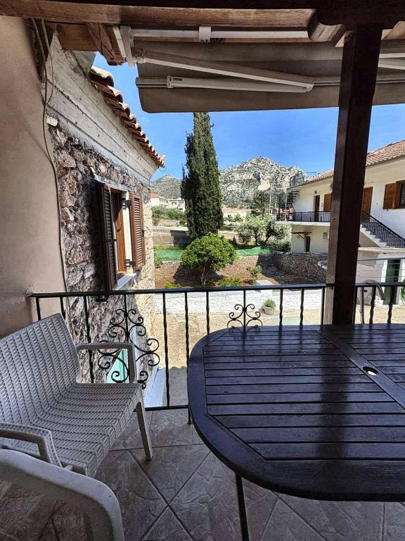 a patio with a table and chairs on a balcony at Leos Traditional Holiday House in Leonidio