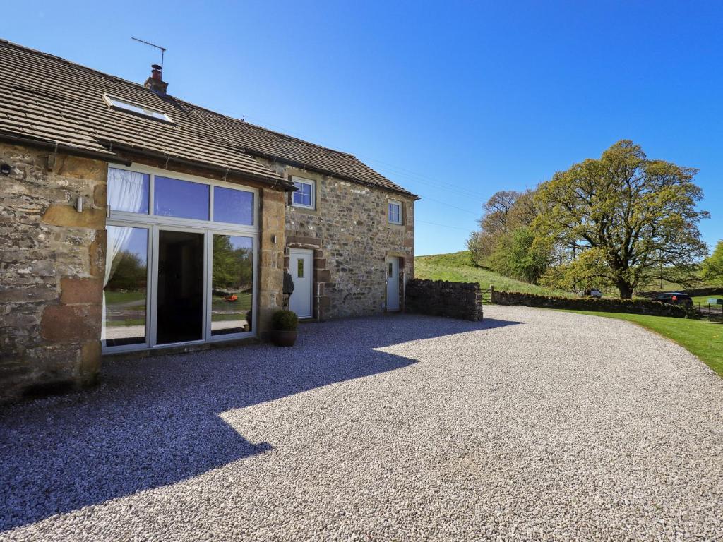 an external view of a stone house with a gravel driveway at Fogga Croft in Skipton