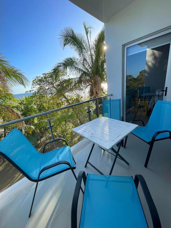 a balcony with a table and chairs and a palm tree at La Jolla in Bejuco