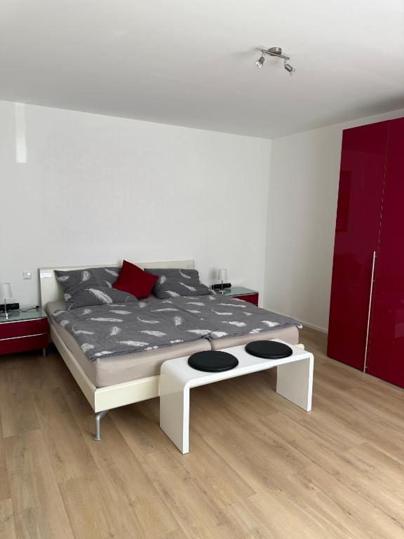 a bedroom with a white bed and red cabinets at Ferienwohnung Ruhepunkt Dessau - zentral nahe Bauhaus und Meisterhäusern - mit gratis WLAN und Parken sowie Komplettküche in Dessau