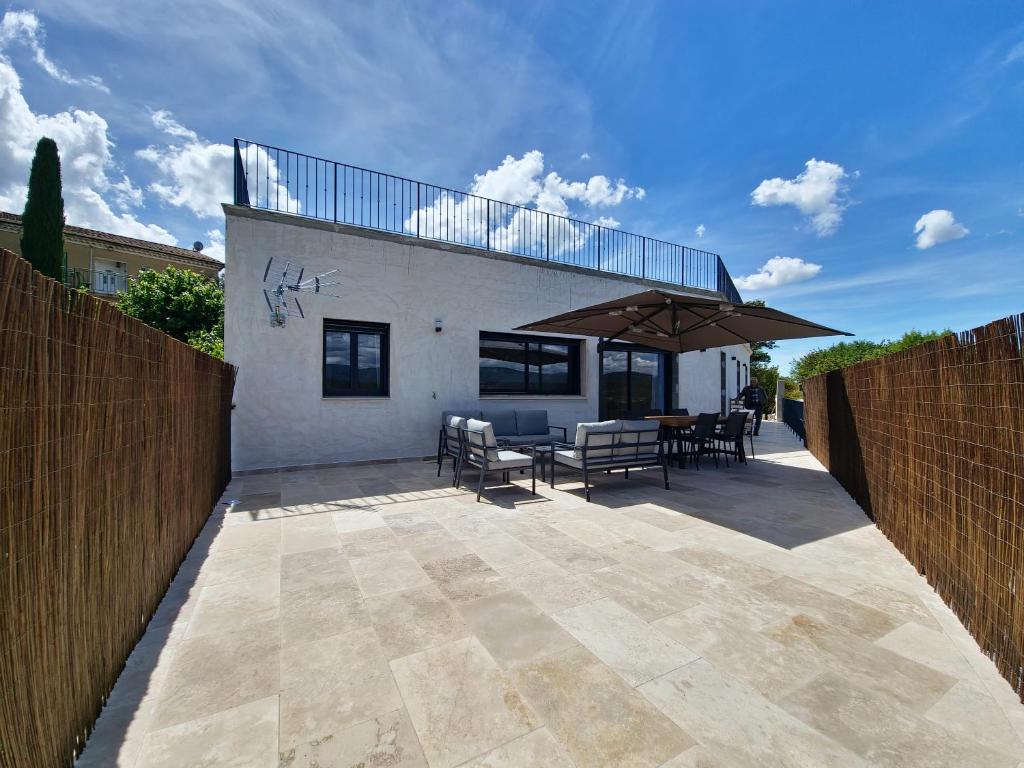 a patio with a table and chairs and a fence at Apt Belvedere in Apt