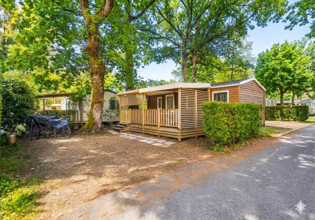a cabin in the woods with a tree at Camping Mobil Home 6 Pers Rivage des Landes Piscine Landes in Aureilhan