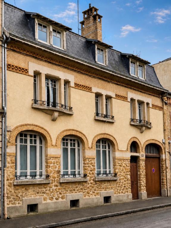 an old brick building with windows and a roof at Le Petit Jard'Inn in Chalons en Champagne