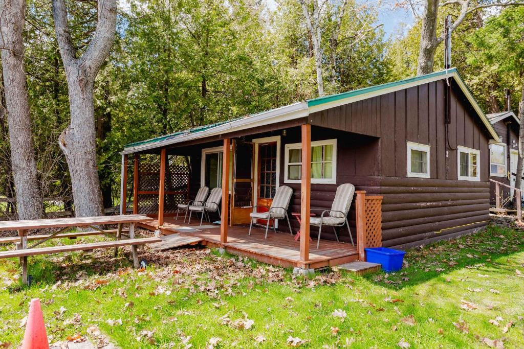 a small cabin with chairs on a deck at Ambleside - 2-Bedroom Cottage #4 in Kawartha Lakes