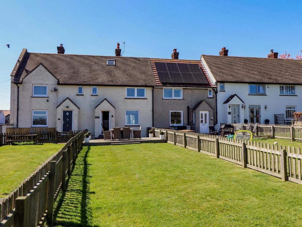 a house with solar panels on the roof at Dunford Cottage in Bamburgh