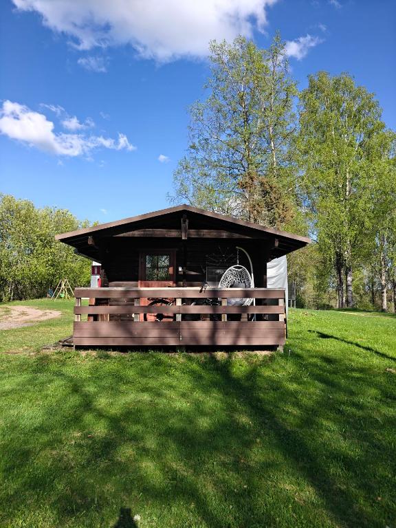 a small building in a grassy field with afficientfficientfficientfficient at Mökki upealla maisemalla in Kouvola
