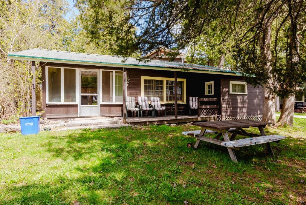 a small house with a picnic table in front of it at 3-Bedroom Cottage #7 - Ambleside in Kawartha Lakes