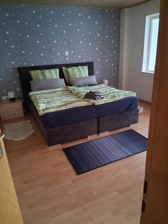 a bedroom with a bed with a wooden floor at Unterkunft mit Kindernische in Ober-Mörlen