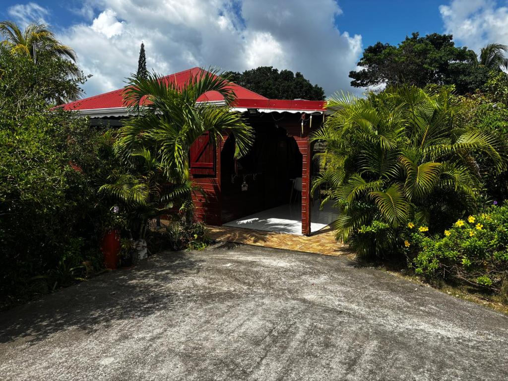 a red house with a red roof and a driveway at Cerise in Sainte-Anne