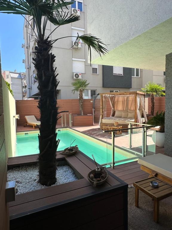 a swimming pool with a palm tree on a building at TULUM luxury suites-SKOPJE in Skopje