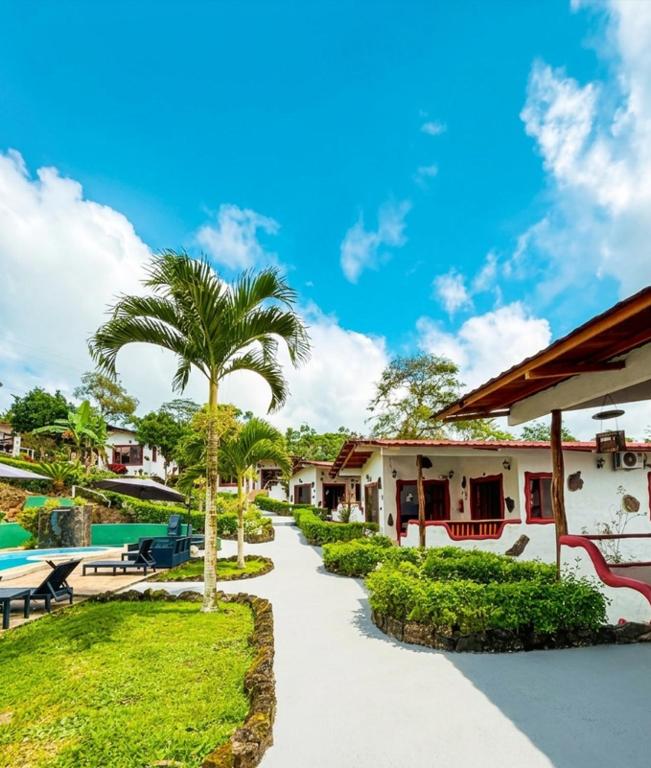 a walkway leading to a resort with a pool at Piedras Blancas Lodge in Puerto Ayora