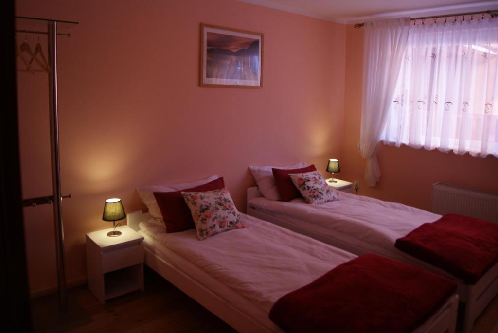 twee bedden in een kleine kamer met twee lampen bij Apartament Ametyst in Jelenia Góra