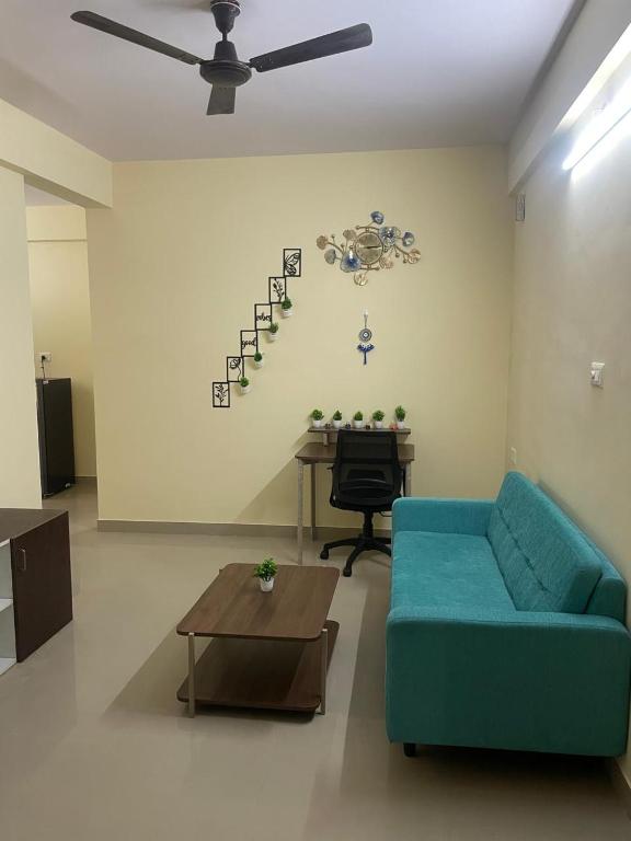 a living room with a blue couch and a table at Stayvora Nest in Bangalore