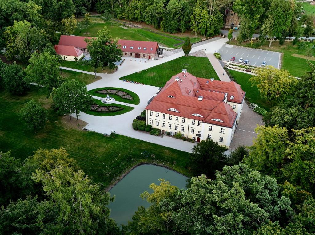 an aerial view of a building with a pond and trees at Pałac Bogaczów - noclegi - restauracja - przyjęcia in Bogaczów