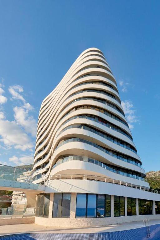 a large white building with a pool in front of it at Mare Sea View Suites ,One Bedroom 305 in Bečići