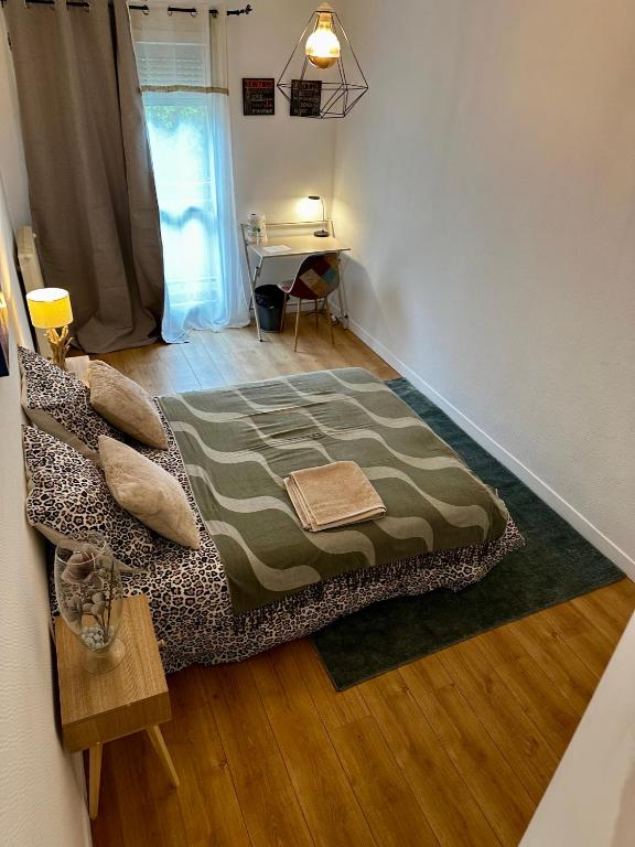 a bedroom with a bed and a table in it at Escale Rennes in Rennes