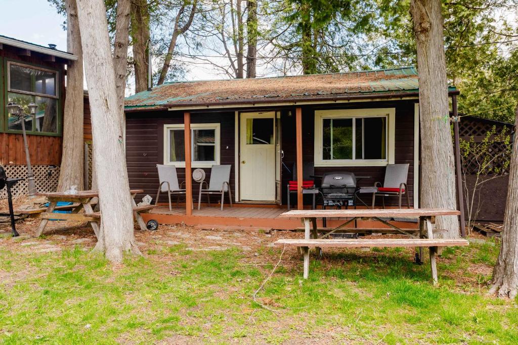 a small cabin with a picnic table in front of it at Ambleside - 2-Bedroom Cottage #8 in Kawartha Lakes