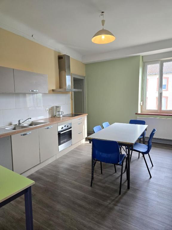 a kitchen with a table and chairs in a room at Gîte VINCENT in Château-Salins