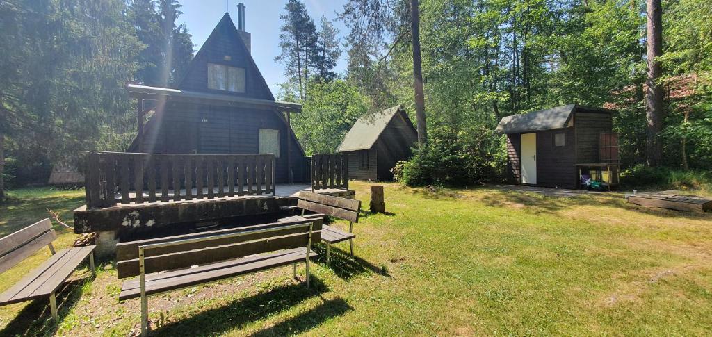 a yard with a house and a bench in the grass at Chata Tatrovice in Tatrovice