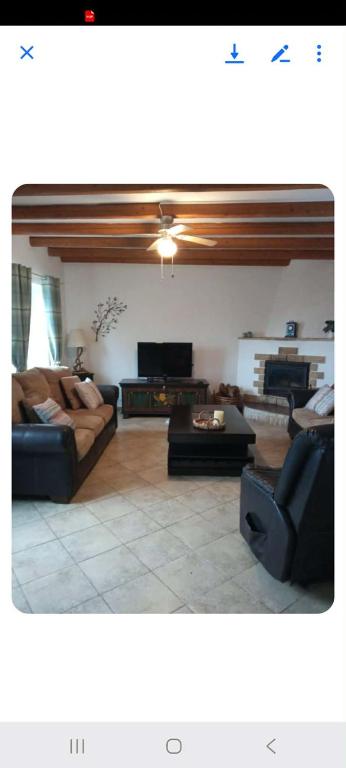 a living room with two couches and a tv at The stone house in Doukádes