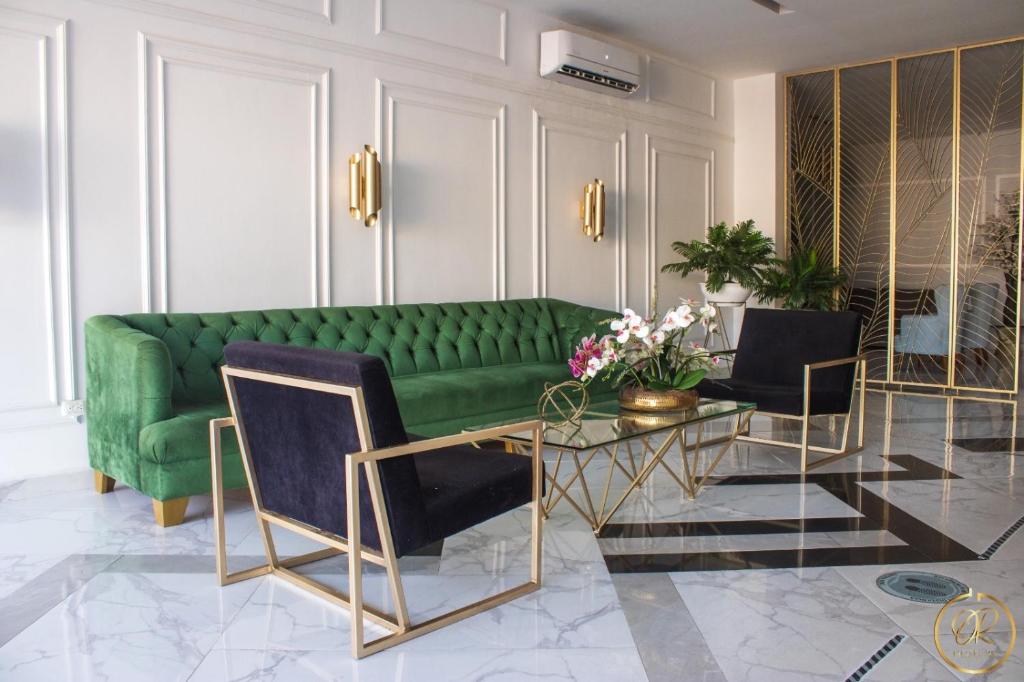 a living room with a green couch and a table at OR HOTEL 94 in Barranquilla