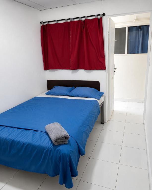 a bedroom with a blue bed and a red curtain at Orison Managua in Managua