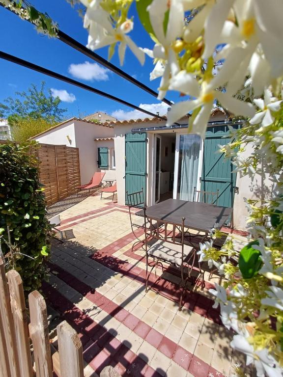 a patio with a table and chairs in front of a house at La dependance in Saint-Gilles