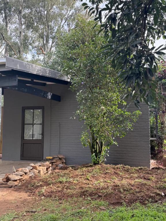 a small house with a tree in front of it at Avo 1 on 27 Drew in Howick