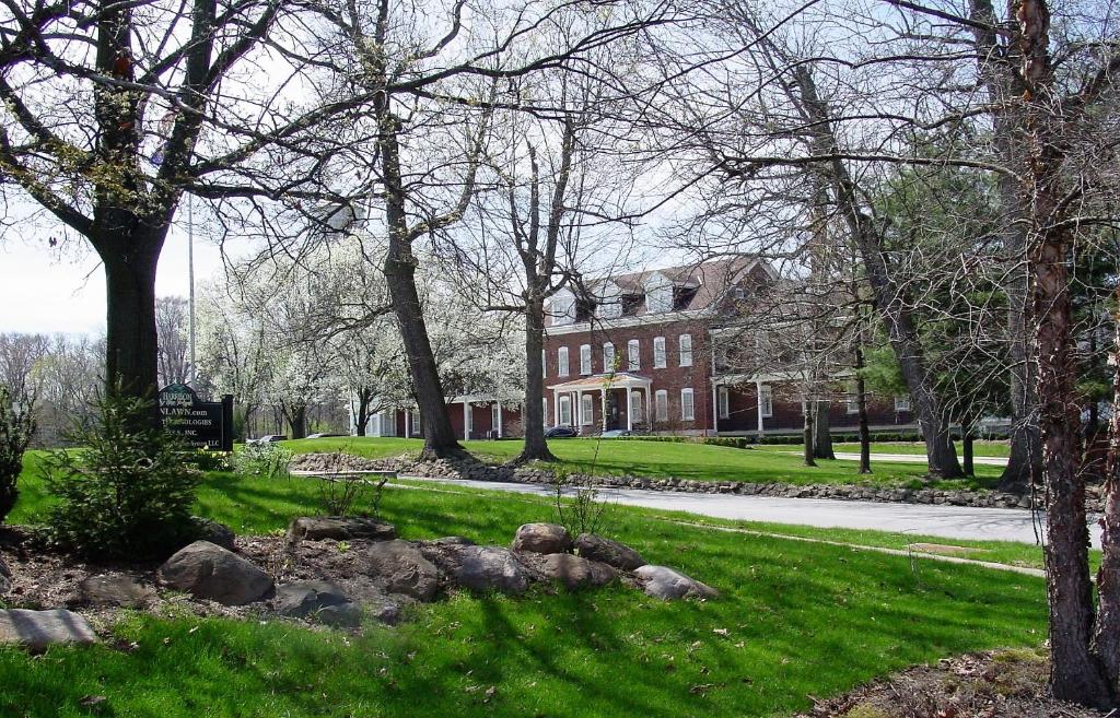 ein großes rotes Backsteingebäude mit Bäumen davor in der Unterkunft Fort Harrison State Park Inn in Indianapolis