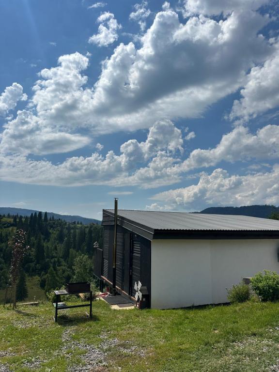 a small white building with a bench next to it at Ecottage котедж для двох у горах із чаном-джакузі in Slavske