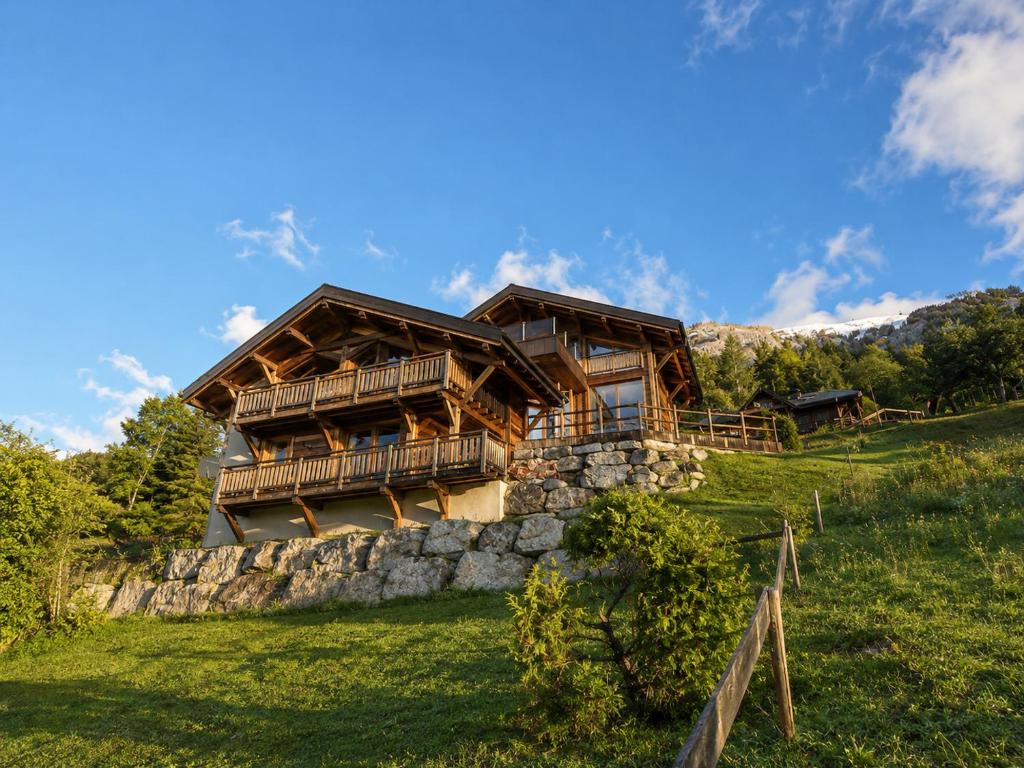 a log house on a hill with a stone wall at Chalet Azalée, Montriond, Morzine, Avoriaz in Montriond