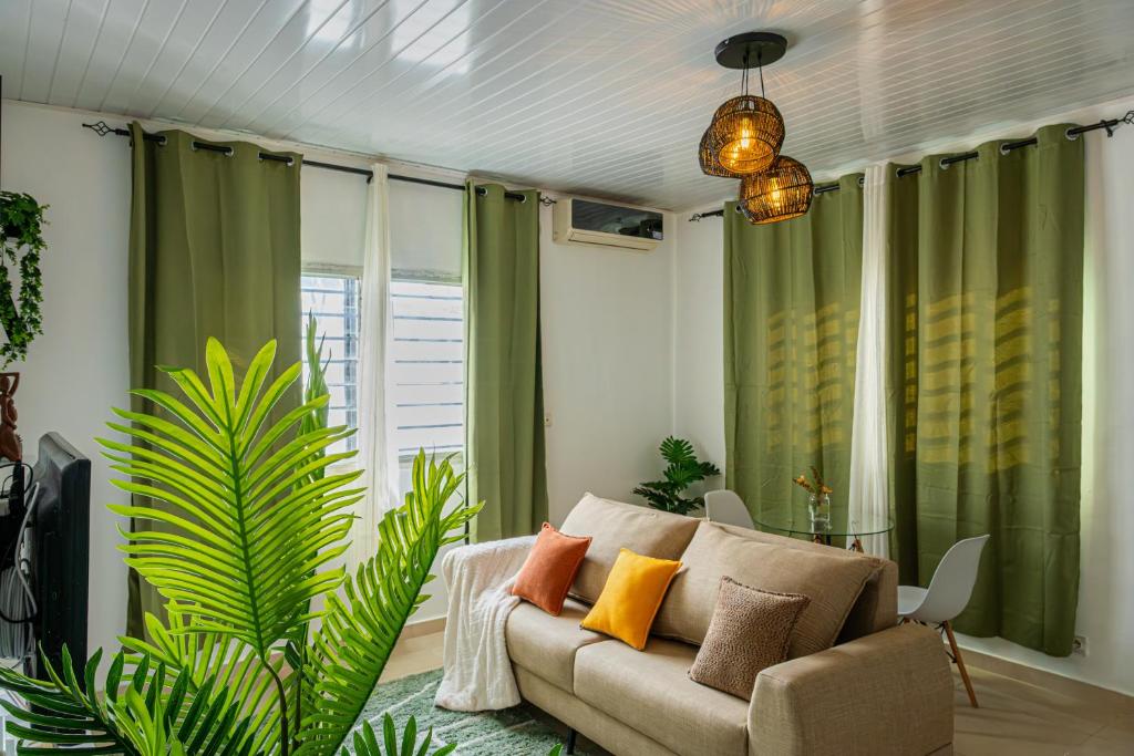 ein Wohnzimmer mit Sofa und Pflanze in der Unterkunft La villa five star in Azuretti