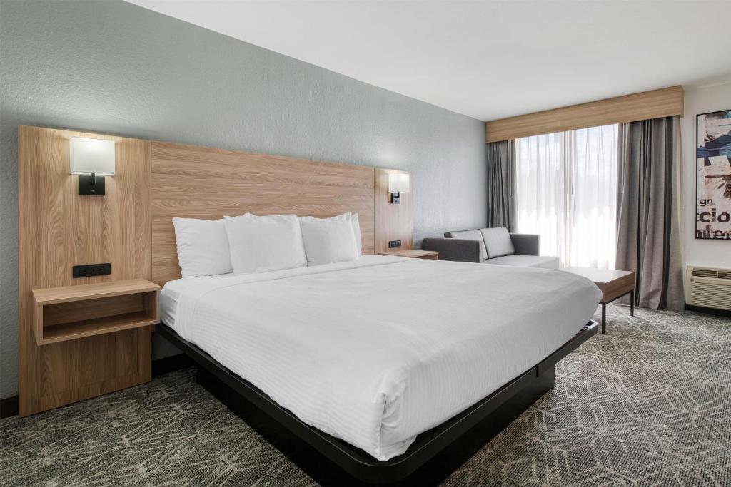 a hotel room with a large bed and a chair at Best Western Tomah Hotel in Tomah