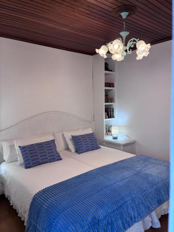a bedroom with a large bed with a blue blanket at O lar da praia in Corcubión