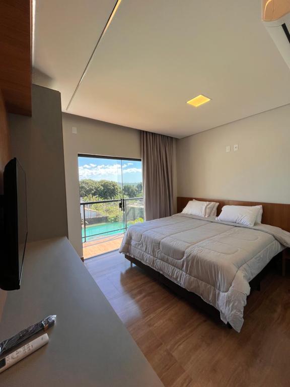 a bedroom with a large bed and a large window at Cascata Boutique Hotel in Várzea da Palma