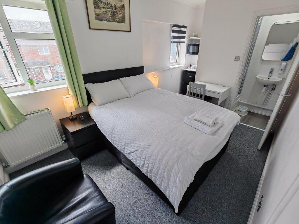a small bedroom with a bed and a chair at Cherry Studio - Self Contained One-Bed Studio Flat in Oxford